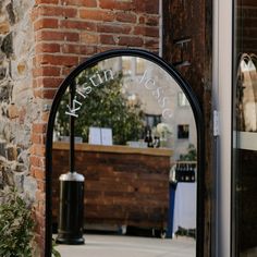 an arched mirror on the side of a brick building