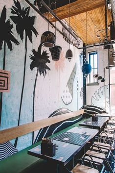 an empty restaurant with palm trees painted on the wall