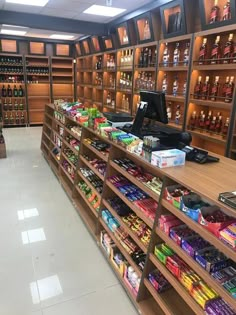 a store filled with lots of bottles and shelves full of drinks on top of wooden shelves