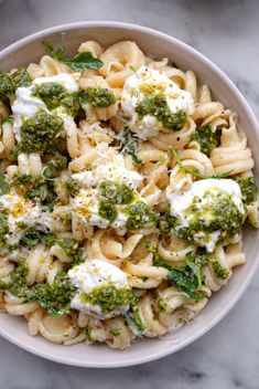 a white bowl filled with pasta and broccoli