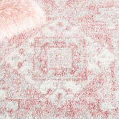 an area rug with red and white designs on the carpet, including a fur ball