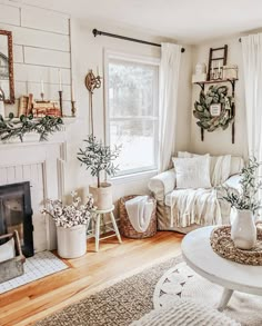 a living room filled with white furniture and lots of plants in vases on the windowsill