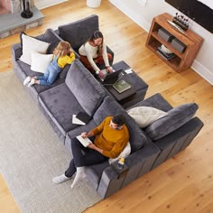 three people sitting on a couch in the middle of a living room with text that reads love sac designed for life furniture co