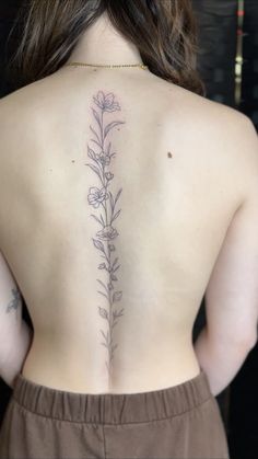 the back of a woman's body with flowers on her upper and lower back