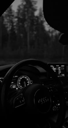 the interior of a car with dashboard lights and steering wheel controls in black and white