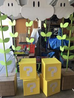 some cardboard boxes are sitting on the ground with plants growing out of them and question marks