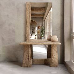 a wooden bench sitting in front of a mirror