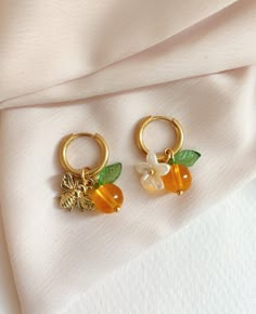 🌸 Description Earrings 🌷Judy🌷 Pretty orange fruit earrings -golden stainless steel hoop earrings -fruit style pendant, glass bead/leaf and acrylic flower/small bee in gold metal 🌸 Colors I try to obtain the most faithful color possible but depending on the phone the colors may be different. Color variations are therefore possible even if they are slight. 🌸Maintenance Tips stainless steel jewelry is resistant to water and wear but as a simple precaution to keep its beauty intact: *Avoid cont Orange Fruit Jewelry, Cute Simple Earrings, Bee Clothes, Cute Gold Earrings, Indie Earrings, Artsy Earrings, Styling Jewelry, Artsy Jewelry, Bee Flower