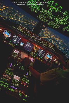 an airplane cockpit with the lights on at night