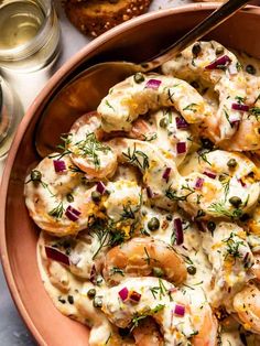 a bowl filled with shrimp and sauce next to bread