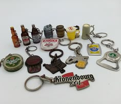 a collection of beer bottle openers and keychains on a white table top