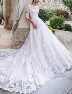 a woman in a wedding dress posing for the camera with her hand on her head