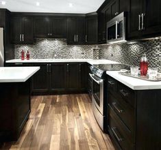 a kitchen with dark wood cabinets and white counter tops