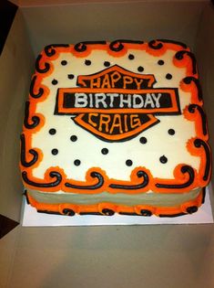 a birthday cake in the shape of a motorcycle with orange and black icing on it