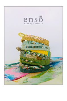 a stack of colorful bracelets sitting on top of a book cover with the title enso made by karteran