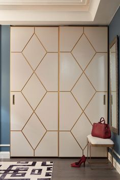 a room with blue walls, white and gold furniture and a red purse on the floor