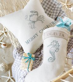 a christmas stocking and some pillows in a basket with seashells on the floor