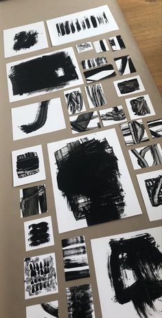 many different black and white paintings on a table