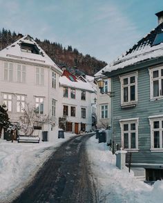 a street with snow on the ground and buildings