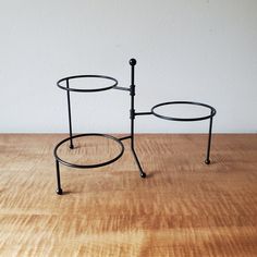 a table that has some sort of metal stand on it's legs and is sitting on top of a wooden surface