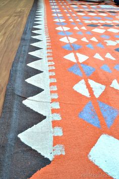 an orange rug with blue and white designs on it