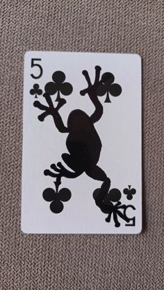 a playing card with a frog on it's back and the number five in front