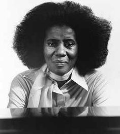 an old black and white photo of a woman with large afros on her head