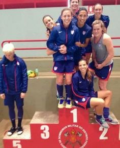 the women's soccer team is posing for a photo on the winners podium with their coach