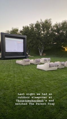 an outdoor movie is set up on the lawn with chairs and couches in front of it