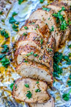 sliced pork roast on foil with parsley sprinkled around the top and sides