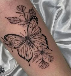 a black and white butterfly tattoo on the arm