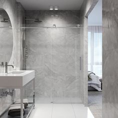 a bathroom with a walk in shower next to a white sink and large mirror on the wall