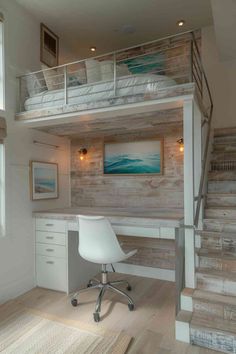 a loft bed with desk underneath and stairs leading up to the second floor, along with a white chair