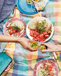 two people are serving themselves food on plates