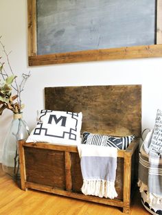 a wooden bench sitting on top of a hard wood floor next to a chalkboard