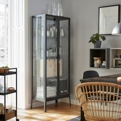 a glass cabinet in the corner of a room