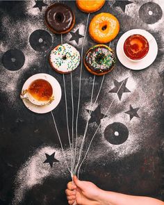 donuts are being held in front of doughnuts with sprinkles