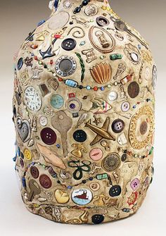 a vase with many different types of buttons on the front and back of it's body