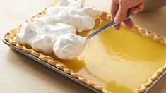 a person cutting into a pie on top of a table