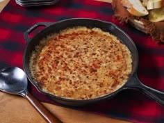 a pan filled with food sitting on top of a table next to a knife and fork