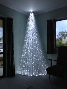 a white christmas tree with lights hanging from it's sides