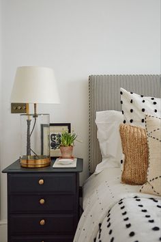 a black and white bed with two nightstands next to each other on top of it