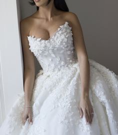 a woman in a wedding dress leaning against a wall