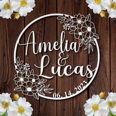 the wedding cake topper is surrounded by white flowers on a wooden background with greenery