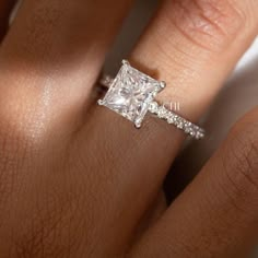 a woman's hand with a diamond ring on her finger and an engagement band