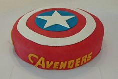 a captain america themed cake with white stars on it's center and the word avengers written in yellow