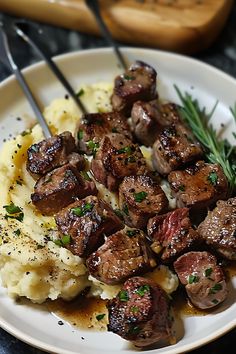 a white plate topped with meat and mashed potatoes