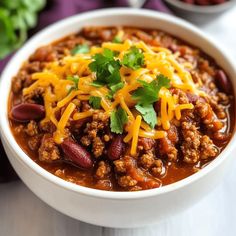 a white bowl filled with chili and cheese