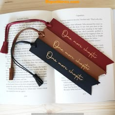 three bookmarks that are on top of an open book