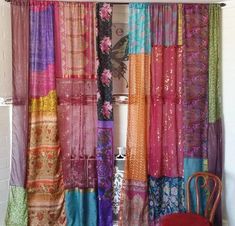 a chair sitting next to a window covered in colorful curtains